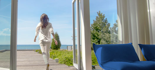 mujer saliendo de casa con vistas al mar