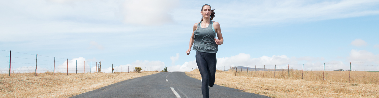 Mujer corriendo por una carretera sin coches