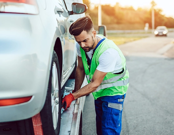 Chico realizando asistencia en carretera a un coche averiado